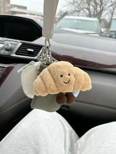 a teddy bear keychain hanging from the inside of a car