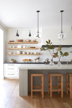 a kitchen with two wooden stools next to an island