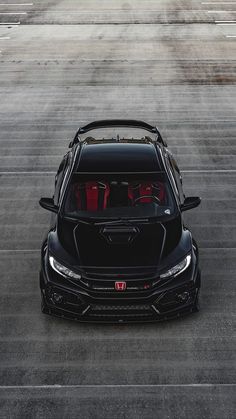 the front end of a black car with red seats in it's trunk and hood