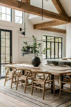 a dining room table with chairs and a vase on it