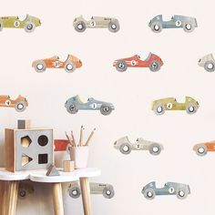 a wall with cars painted on it next to a wooden table and small toy truck