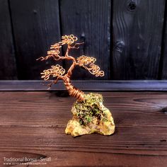 a wire tree sculpture on top of a rock