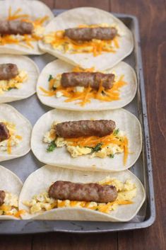 breakfast burritos with sausage, eggs and cheese on a baking sheet ready to go into the oven