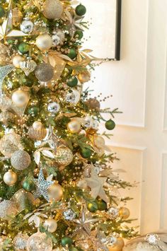 a decorated christmas tree with gold, silver and green ornaments