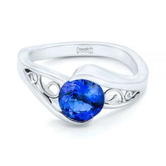 a ring with a blue stone in the center and an intricate design on the band