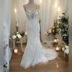 a wedding dress on display in front of candles