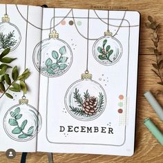 an open christmas planner with ornaments and greenery on the pages, next to pencils