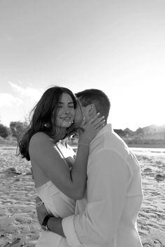 a man and woman are kissing on the beach