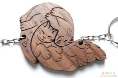 a wooden keychain with an image of two cats on it's back