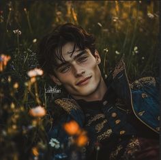 a young man laying in the grass with his eyes closed and looking at the camera