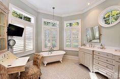 a large bathroom with two sinks and a bathtub in the middle of the room