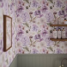 a bathroom with purple flowers on the wall and shelving in the corner next to the bathtub