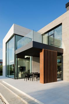 a modern house with large glass windows and wooden slats