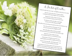 a bouquet of flowers sitting on top of a wooden table next to a poem written in white