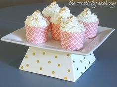 cupcakes with white frosting and gold sprinkles on a plate