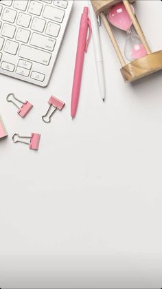 pink office supplies on white desk with keyboard and mouse