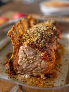 a piece of meat sitting on top of a pan covered in spices and seasoning