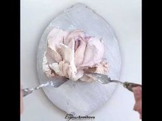 a person is painting a flower on a plate