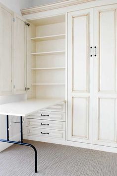 an empty room with white cabinets and drawers