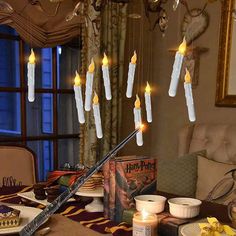 a dining room table with candles hanging from the ceiling