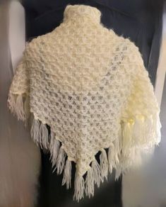 a white shawl with tassels on it