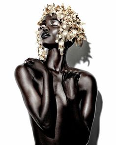 a woman with dark skin and white flowers on her head is posing for the camera