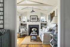 a living room filled with furniture and a fire place next to a doorway that leads to another room