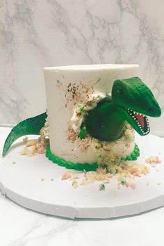 a dinosaur cake with sprinkles and frosting on it's head