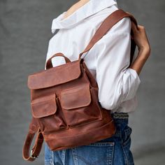 Genuine leather minimalist backpack. Zipper closure and large front pocket. DIMENSIONS: MEDIUM - 26 cm (10.2 inch) x 24 cm (9.5 inch) LARGE - 36 cm (14.2 inch) x 35 cm (13.8 inch) - Carabiner closure on the flap; - Adjustable shoulder straps; - Top carrying handle; - Laptop section can be added upon request. Eight colors are available. Your item may be personalized according to your wish. See the banners for more information. Everyday Leather Backpack With Pockets, Rectangular Leather Backpack With Pockets For Everyday Use, Daily Use Leather Backpack With Pockets, Everyday Backpack With Pockets, Leather Backpack With Pockets, Leather School Backpack With Pockets, Waxed Finish Satchel Backpack For School, Canvas Backpack With Pockets, Standard Backpack With Silt Pocket For Daily Use