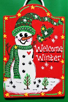 a welcome winter sign with a snowman on it's front and green background