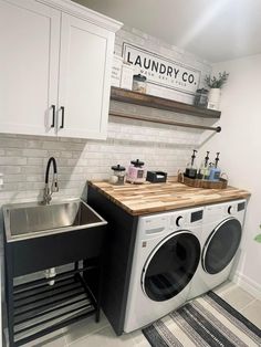 a washer and dryer in a laundry room with white cabinets on the wall