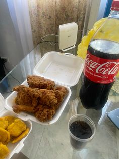 a table with two trays of food and a coke