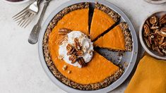 a pie with pecans and whipped cream sits on a plate next to other desserts