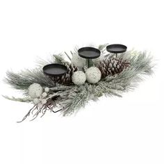 three candles are sitting on top of some pine cones and snowflakes, with white balls in the center