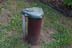 a green trash can sitting in the grass