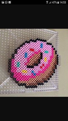 an image of a pink donut made out of perler beads on a pin board