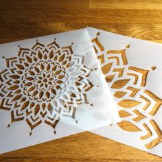 two pieces of paper cut out to look like snowflakes on a wooden table