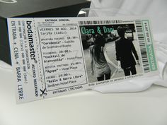 a pair of concert tickets sitting on top of a white table next to a black box