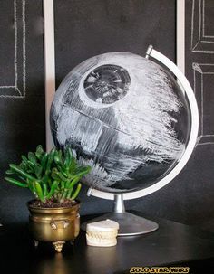 a potted plant sitting on top of a table next to a black and white globe