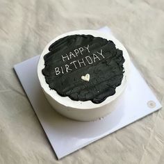 a birthday cake with the words happy birthday written on it sitting on top of a piece of paper