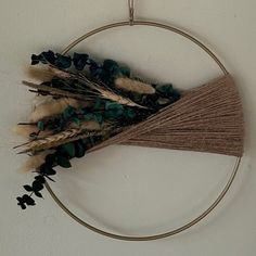 a circular hanging decoration with dried flowers and leaves