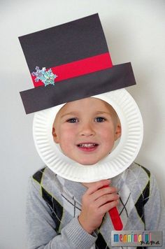 a young boy wearing a paper plate hat