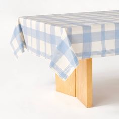 a blue and white checkered table cloth on top of a wooden leg with a wood base