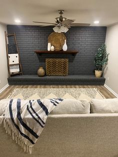 a living room with a couch, fireplace and fan