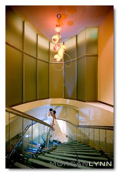 a woman in a white dress is walking down the stairs