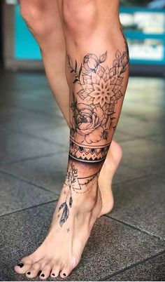 a woman's legs with tattoos and flowers on her leg, in front of a tiled floor