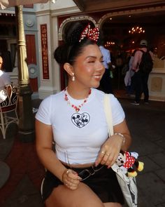 a woman sitting on the ground wearing minnie mouse ears