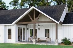 a white house with an open porch and covered patio area in the middle of it