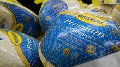 blue and yellow bags of bread sitting on top of each other in a store display