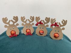 three reindeer ornaments with red bows on them